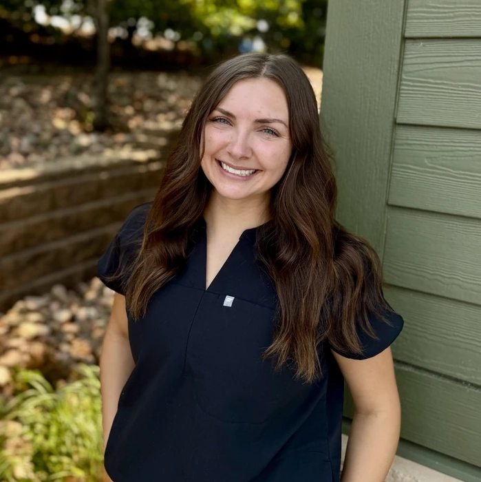 Team member at Green Dental Care smiles outdoors