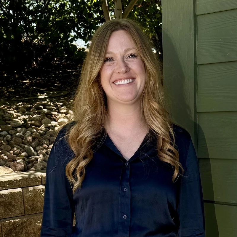 Dr. Emily Carter, Dentist at Green Dental Care, smiling outdoors.