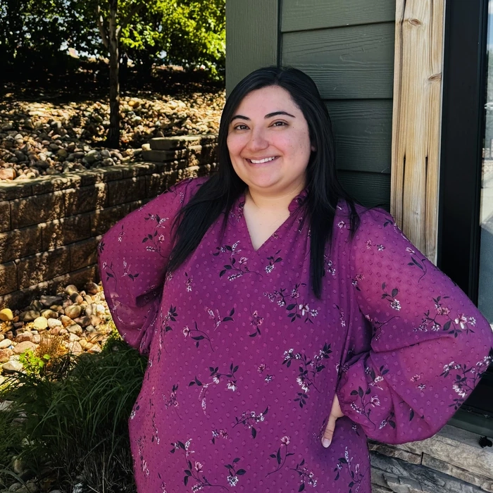 Team member at Green Dental Care smiling outdoors.