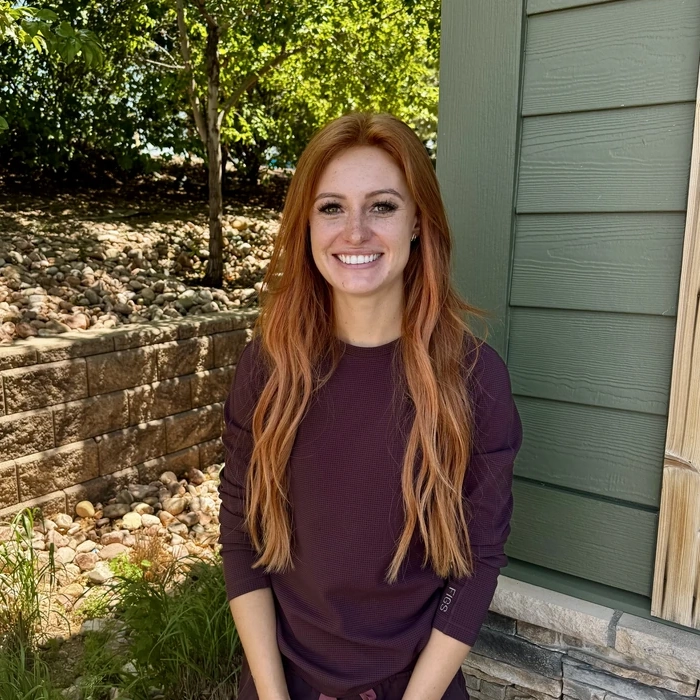 Team member at Green Dental Care, a smiling woman with red hair