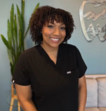 A smiling woman in Green Dental Care scrubs